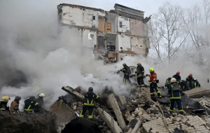 Украинские пожарные работают на месте ракетного удара в Харькове